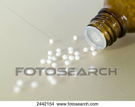 Close-up of homeopathic pills spilling from bottle View Large Photo Image Picture - Close-up of homeopathic pills spilling from bottle . Fotosearch