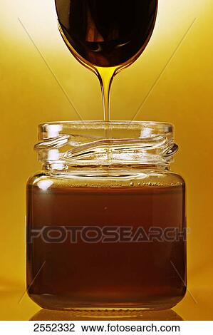 Close-up of honey dripping from spoon into jar View Large Photo Image Stock Image - Close-up of honey dripping from spoon into jar . Fotosearch