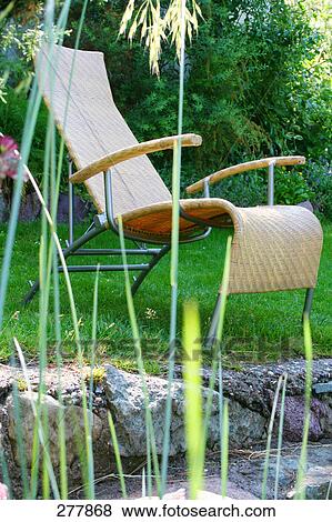 Close-up of lawn chair in lawn View Large Photo Image Stock Photo - Close-up of lawn chair in lawn . Fotosearch