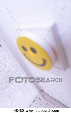 Stock Image - Close-up of light switch with smiley face . Fotosearch