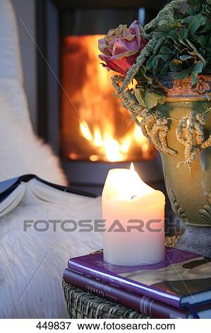 Stock Photo - Close-up of lit candle on book . Fotosearch