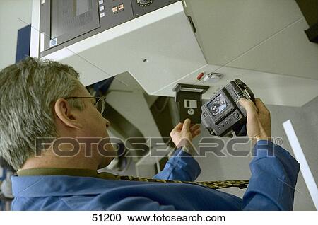 Stock Image - Close-up of male mechanic repairing digital camera . Fotosearch