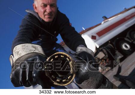 Close-up of man holding oil nozzle View Large Photo Image Stock Image - Close-up of man holding oil nozzle . Fotosearch