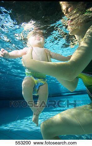 Close-up of mother helping her baby to swim underwater View Large Photo Image Stock Image - Close-up of mother helping her baby to swim underwater . Fotosearch