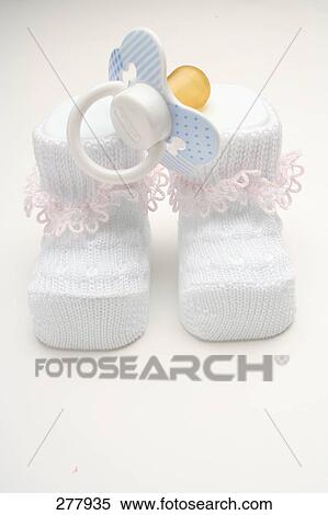 Close-up of pair of baby booties and pacifier  View Large Photo Image Stock Photography - Close-up of pair of baby booties and pacifier . Fotosearch