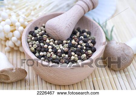 Stock Photo - Close-up of peppercorns in mortar with pestle . Fotosearch