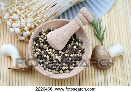 Stock Photograph - Close-up of peppercorns in mortar with pestle . Fotosearch
