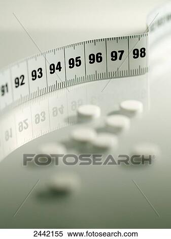 Stock Photography - Close-up of pills and tape measure . Fotosearch