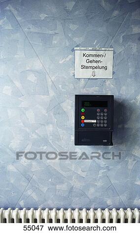 Stock Photo - Close-up of punch clock dial recorder on wall . Fotosearch