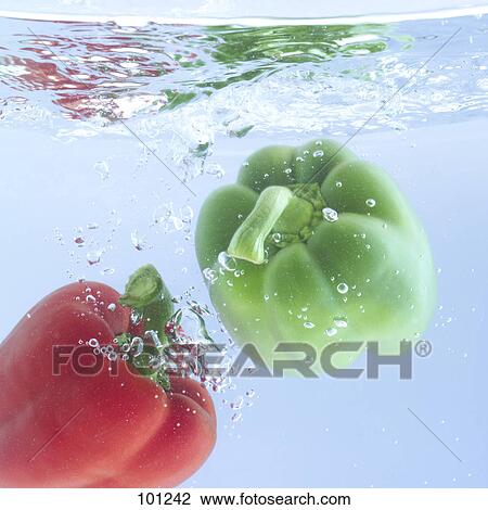 Stock Image - Close-up of red and green bell peppers in water . Fotosearch