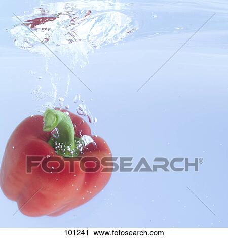 Stock Image - Close-up of red bell peppers splashing in water . Fotosearch