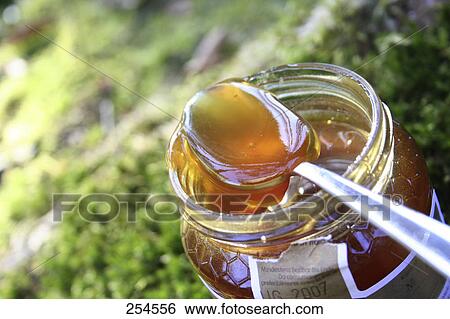 Close-up of spoon in jar of honey View Large Photo Image Stock Photograph - Close-up of spoon in jar of honey . Fotosearch