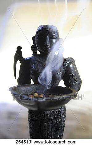 Close-up of statue and incense View Large Photo Image Stock Photo - Close-up of statue and incense . Fotosearch