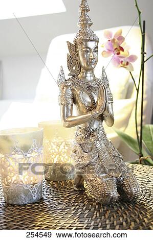Stock Photo - Close-up of statue of Buddha and lamps . Fotosearch