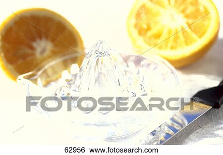 Stock Photograph - Close-up of two halves of oranges with juicer . Fotosearch