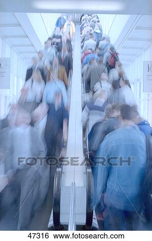Stock Photograph - Crowd of people on escalator . Fotosearch