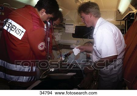 Picture - Emergency doctors examining patient lying on strecher . Fotosearch