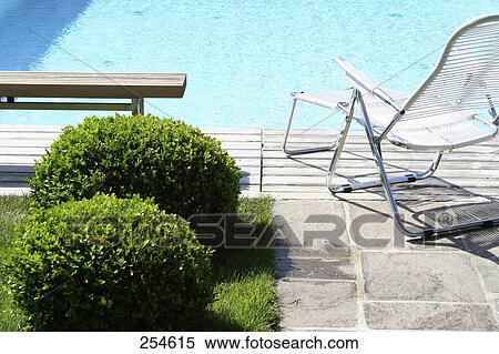 Empty bench and lounge chair at edge of swimming pool View Large Photo Image Stock Photography - Empty bench and lounge chair at edge of swimming pool . Fotosearch