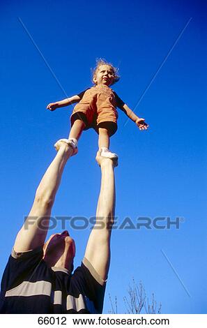 Father lifting up daughter, low angle view View Large Photo Image Stock Image - Father lifting up daughter, low angle view . Fotosearch