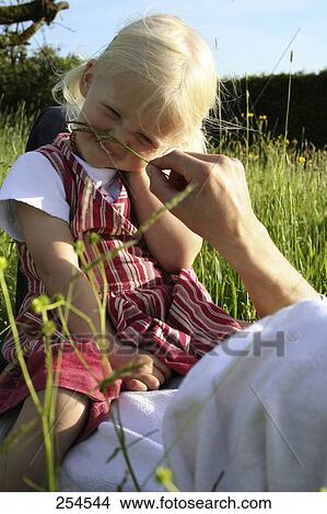 Picture - Father playing with his daughter in field . Fotosearch