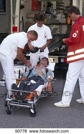 First aid doctor helping patient on stretcher View Large Photo Image Stock Photo - First aid doctor helping patient on stretcher . Fotosearch