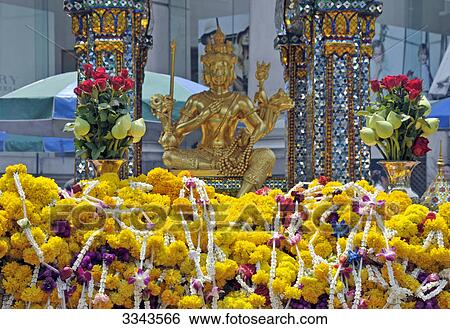 Flower arrangement and golden buddha statue View Large Photo Image Stock Photograph - Flower arrangement and golden buddha statue . Fotosearch