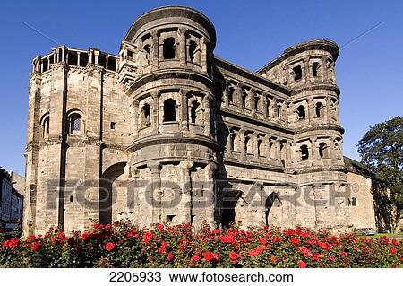 Stock Image - Flowers blooming in front of old roman building, Porta Nigra, Trier, Rheinland-Pfaltz, Germany . Fotosearch