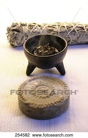 Stock Image - High angle view of burning incense in bowl . Fotosearch