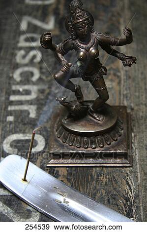 Stock Photo - High angle view of Hindu Goddess Saraswati and incense . Fotosearch