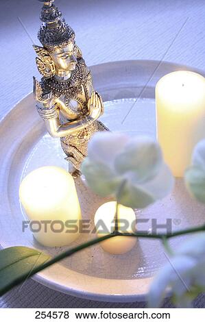 High angle view of lit candles and statue of Buddha on plate View Large Photo Image Stock Photo - High angle view of lit candles and statue of Buddha on plate . Fotosearch