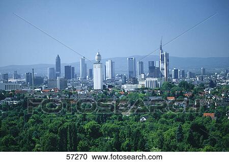 Stock Image - High angle view of trees with city in background, Frankfurt, Taunus Mountains, Hesse, Germany . Fotosearch