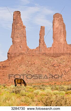 Stock Image - Horse grazing in front of natural columns, Monument Valley, Utah, USA . Fotosearch