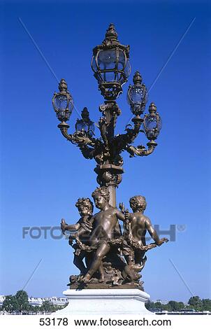 Stock Photo - Lamppost with statues on bridge, Pont Alexandre III, Paris, Ile-de-France, France . Fotosearch