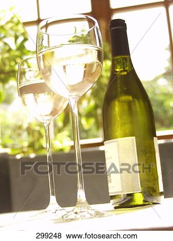 Low angle view of glasses and bottle of white wine View Large Photo Image Stock Photo - Low angle view of glasses and bottle of white wine . Fotosearch