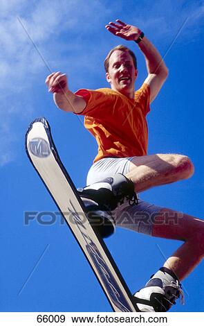 Low angle view of man snowboarding View Large Photo Image Stock Photo - Low angle view of man snowboarding . Fotosearch