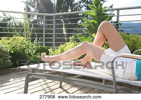 Stock Photo - Low section view of teenage girl resting on lounge chair . Fotosearch