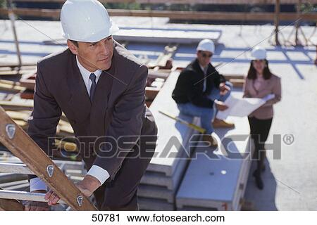 Stock Image - Male architect working at construction site . Fotosearch