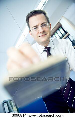 Man holding a stamp towards camera, facing camera, low angle view, close-up View Large Photo Image Picture - Man holding a stamp towards camera, facing camera, low angle view, close-up . Fotosearch