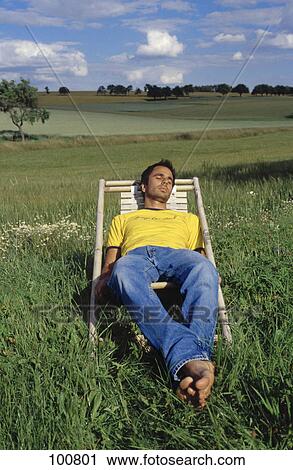 Man sitting in deck chair, elevated view View Large Photo Image Stock Image - Man sitting in deck chair, elevated view . Fotosearch