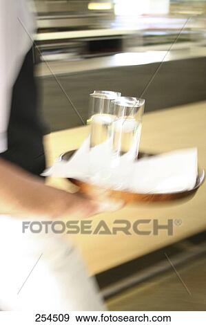 Stock Photo - Mid section view of waiter holding tray of glasses . Fotosearch