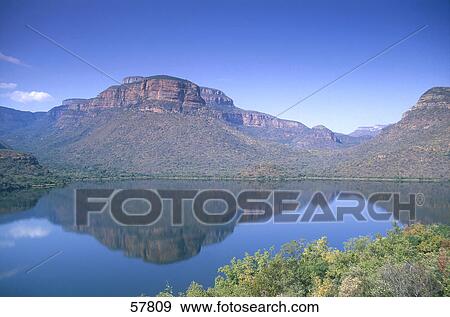 Stock Photo - Mountains reflected on a lake, Blyde River Canyon, Mpumalanga, South Africa . Fotosearch