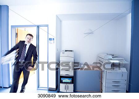 Stock Photo - Overworked businessman entering a room, blurred motion, front view . Fotosearch