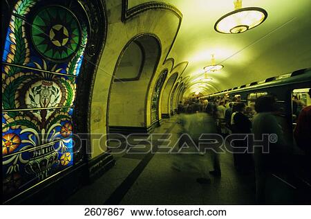 Stock Photo - Passengers at lit up subway station . Fotosearch