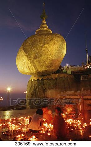 Stock Photo - People lightning candles in front of temple, Kyaikto, Myanmar . Fotosearch