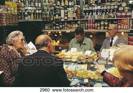 Stock Image - People shopping for cheese in a shop, Baixa, Lisbon, Portugal, Europe . Fotosearch