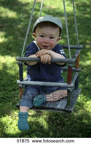 Stock Photography - Portrait of baby sitting on swing . Fotosearch