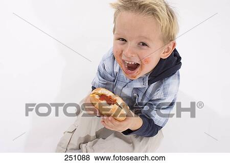 Portrait of boy holding hamburger and shouting View Large Photo Image Stock Photo - Portrait of boy holding hamburger and shouting . Fotosearch