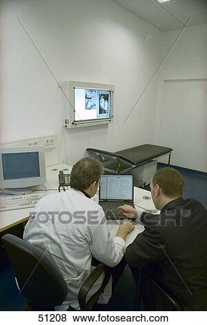 Stock Photo - Rear view of two doctors using laptop . Fotosearch