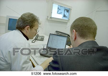 Rear view of two doctors using laptop View Large Photo Image Stock Photograph - Rear view of two doctors using laptop . Fotosearch