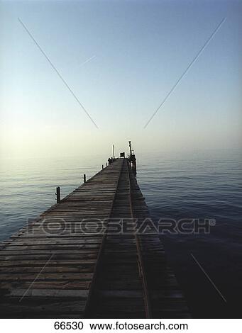Stock Image - Rotten footbridge leading to sea . Fotosearch